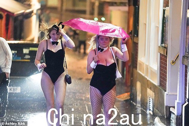 两名戴着兔子耳朵、打着领结的女学生,粉红色的雨伞被暴风雨吹坏了,努力保持干燥