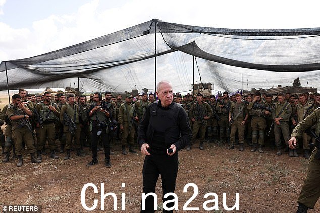 身穿防护背心的国防部长 Yoav Gallant 在以色列南部加沙地带边境附近的集结区与以色列士兵交谈