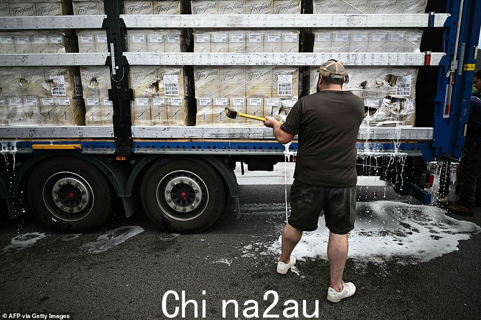 心怀不满的葡萄种植者用大锤毁坏了酒瓶