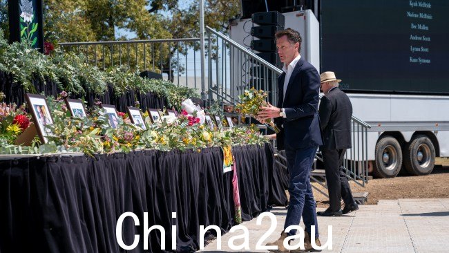 克里斯·明斯 (Chris Minns) 在照片前献花，纪念在猎人谷巴士事故中丧生的 10 名生命。图片：新南威尔士州政府
