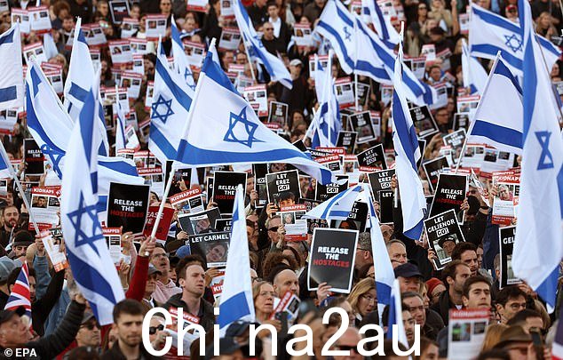在一场活动中,举着以色列国旗的人群高呼“带他们回家”,以突显据信被哈马斯俘虏的妇女、男子和儿童的痛苦