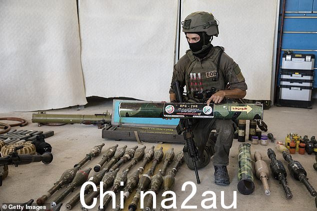 一名以色列士兵在向媒体介绍哈马斯和巴勒斯坦武装分子于 2023 年 10 月 20 日袭击以色列与加沙地带南部边境时使用的军事装备和弹药时展示哈马斯制造的火箭弹。以色列基里亚特马拉基