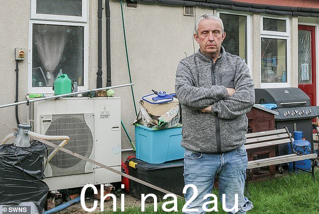 Nigel Cleall 在他的家里,在他的空气源热泵旁边,他说导致账单急剧上升