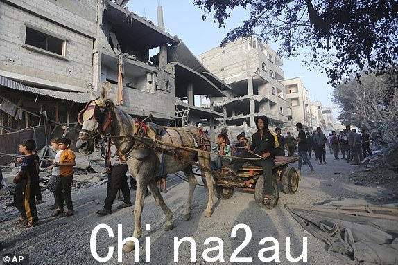 周三,巴勒斯坦人在拉法观看以色列轰炸加沙地带造成的破坏, 2023 年 10 月 25 日。(美联社照片/Hatem Ali)