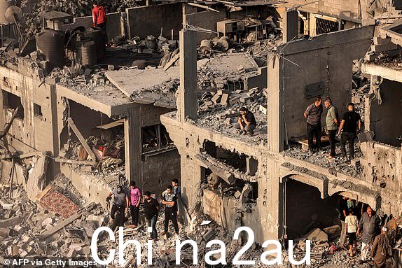 TOPSHOT - 2023 年 10 月 25 日，在以色列和巴勒斯坦组织哈马斯之间持续不断的战斗中，人们在加沙地带南部汗尤尼斯的以色列轰炸中被摧毁的建筑物中寻找幸存者和受害者的尸体。 .（摄影：MAHMUD HAMS/法新社）（摄影：MAHMUD HAMS/法新社，盖蒂图片社）