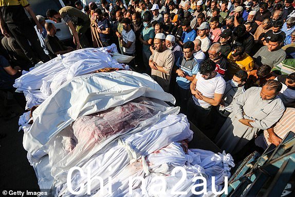 KHAN YUNIS,加沙 - 10 月 26 日：（编者注：图片描绘了死亡。）人们在收集 2023 年 10 月 26 日在加沙汗尤尼斯的以色列空袭中丧生的巴勒斯坦人的尸体时哀悼。以色列的猛烈轰炸已进入第三周，加沙因燃料等基本需求短缺而陷入困境，加沙地带的几个社区已被摧毁，数千人死亡，数十万人流离失所。 10月7日，哈马斯在以色列南部发动致命袭击，引发对加沙的报复性围攻。 （艾哈迈德·哈萨巴拉/盖蒂图片社拍摄）