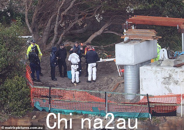 可以看到一名男子正在系上安全带,警察准备将他从岩石上绞起