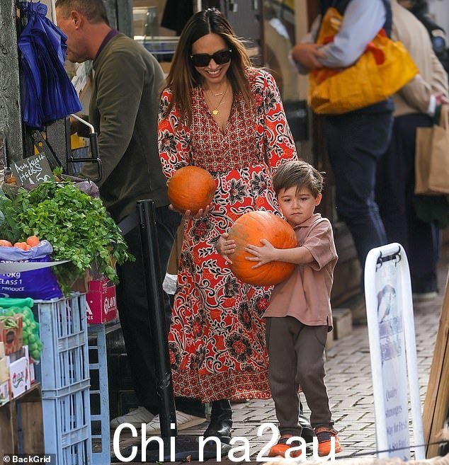 比看起来更重:Myleene 咯咯地笑,因为她看着坚定的阿波罗与一个大南瓜挣扎,而她拿着一个小南瓜