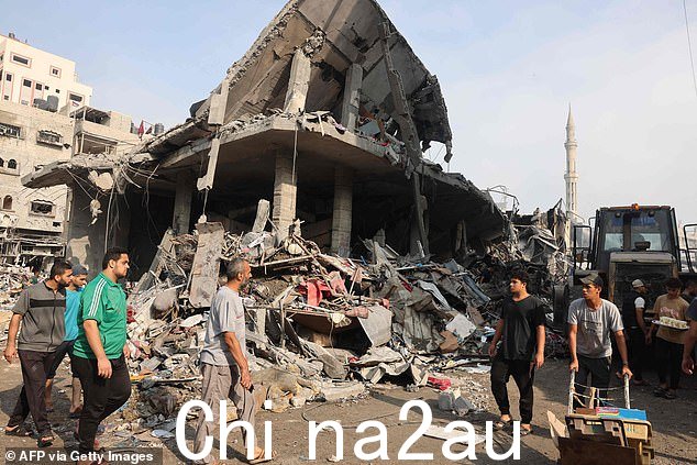 人们聚集在加沙北部 Al-Shatee 难民营的街道上,该难民营在周六一夜之间遭受了以色列的猛烈轰炸