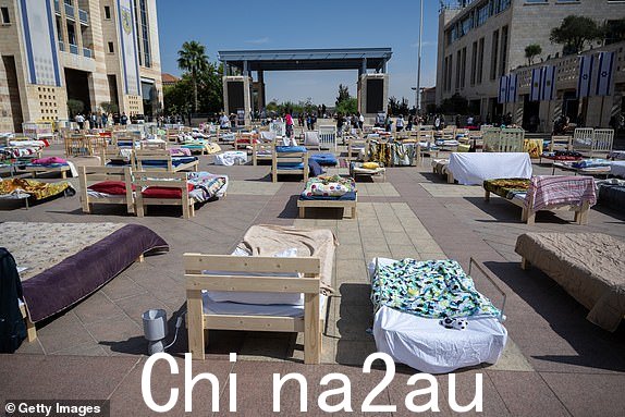 以色列耶路撒冷- 10 月 30 日：2023 年 10 月 30 日，以色列耶路撒冷萨夫拉广场，人们参观空床装置，其中包含代表人质的 230 张床和摇篮。该装置将展出四天，然后设备和床位将捐赠给从加沙地带撤离的人们。以色列政府发誓要消灭哈马斯（哈马斯 10 月 7 日的袭击造成 1,400 人死亡、230 人被绑架），这些人质的命运使该国的军事反应变得复杂化。受害者家属担心，军事攻势可能导致人质在以色列轰炸或哈马斯报复中丧生。留在加沙的人质的一些家人和朋友呼吁政府交换巴勒斯坦囚犯。 （照片由 Alexi J. Rosenfeld/Getty Images 拍摄）