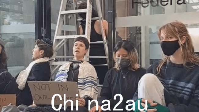 抗议者使用自行车锁将自己固定在梯子上。图片:X