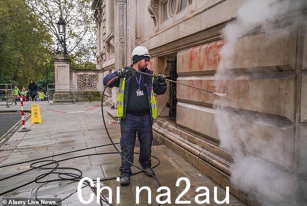 昨天,外交部遭到破坏者袭击后,一名市议会工作人员今天清除了外交部的红色涂鸦