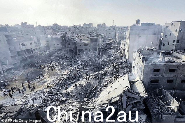 巴勒斯坦人检查加沙地带贾巴利亚难民营遭到袭击后的破坏情况