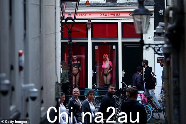 2020 年 7 月 1 日阿姆斯特丹红灯区的妓女站在窗户后面