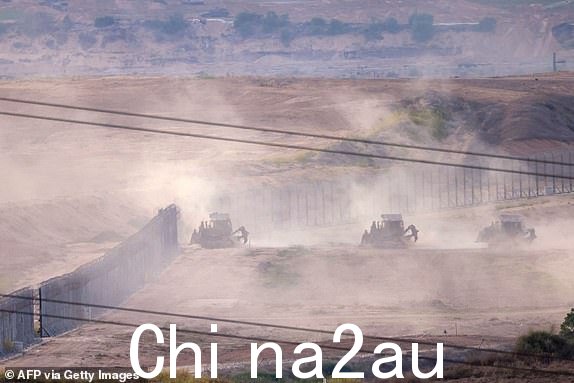 从南部拍摄的照片2023 年 10 月 29 日,以色列与加沙地带边境沿线的以色列军队推土机越过边境进入加沙,以色列和巴勒斯坦激进组织哈马斯之间的战斗仍在继续。以色列遭受哈马斯袭击一个月后,人们的生活发生了翻天覆地的变化。巴勒斯坦和以色列在加沙地带发动报复战争。10 月 7 日,哈马斯武装分子从加沙冲过,袭击了基布兹和以色列南部地区,造成 1,400 人死亡,其中大部分是平民,给整个国家带来了深深的创伤。哈马斯控制的加沙卫生部表示,近 9,500 人被杀,其中三分之二是妇女和儿童,大部分是平民。 (摄影:Menahem KAHANA/法新社)(摄影:MENAHEM KAHANA/法新社,盖蒂图片社)