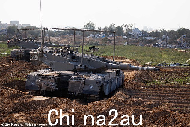 周一,以色列发起地面行动后,两辆以色列国防军梅卡瓦坦克穿过加沙北部的一片田野