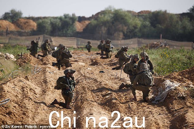 周一,步兵跪在加沙北部的土路上,准备继续袭击加沙城