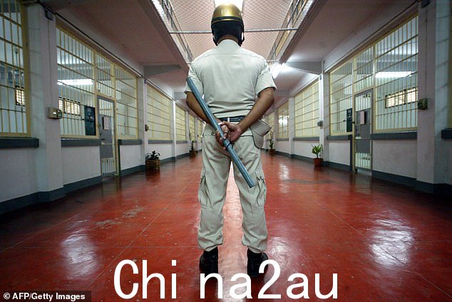 2002 年,一名狱警拿着警棍站在 Klong Prem 监狱的宿舍里