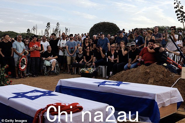 哀悼者参加 10 月 29 日在 Palmachim 公墓举行的 Meni 和 Ayelet 夫妇的葬礼。这对夫妇在 10 月 7 日的袭击中被哈马斯枪手杀害