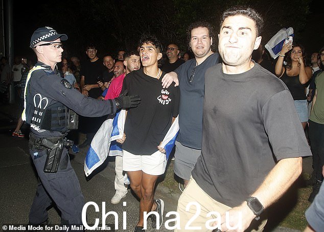 当巴勒斯坦支持者在抗议期间花一些时间祈祷时,以色列支持者唱歌