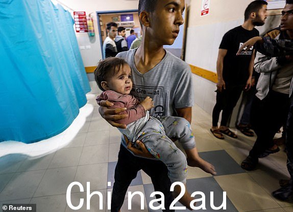 以色列袭击后，一名男子在医院里抱着一名巴勒斯坦儿童， 2023 年 11 月 13 日，以色列与巴勒斯坦组织哈马斯在加沙地带南部汗尤尼斯发生冲突。REUTERS/Mohammed Salem