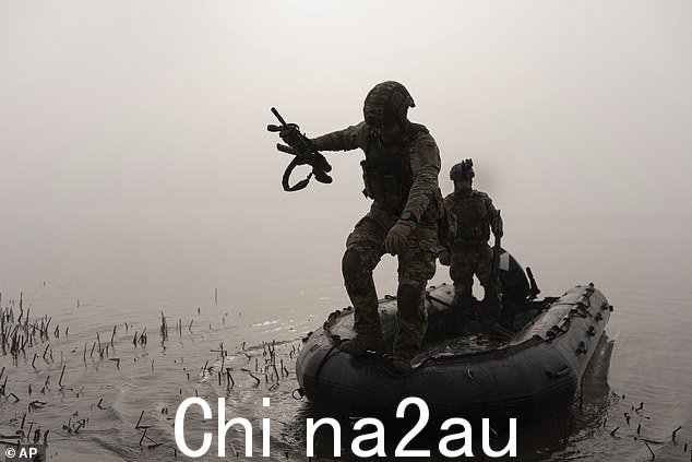 2023 年 10 月 15 日星期日,乌克兰赫尔松附近前线,一名乌克兰军人从船上跳到第聂伯罗海岸上