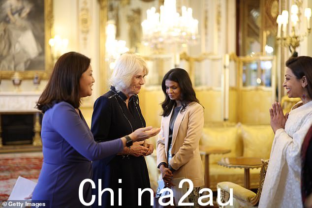 卡米拉在白金汉宫主持招待会时与 Akshata Murty(中)和 Linda Yueh 博士(左)交谈