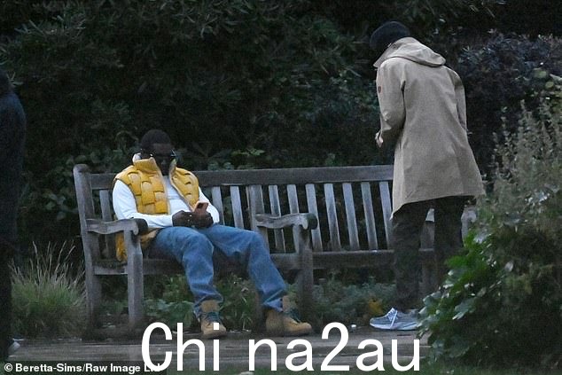 低调:有人看到他坐在公园长椅上打电话,而他的随从则站在附近