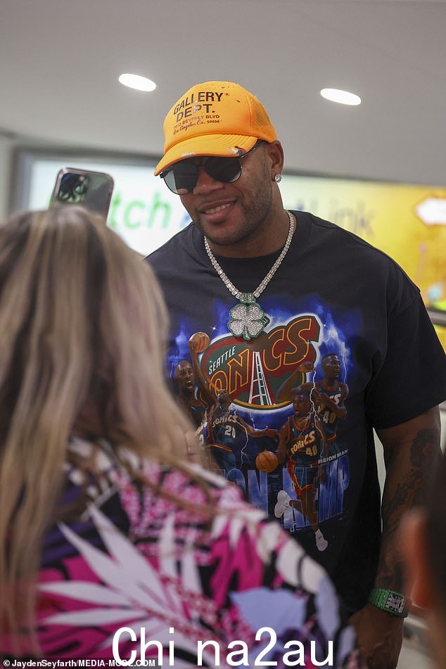 低人气歌手弗洛·里达 (Flo Rida) 穿着西雅图超音速队黑色 T 恤,戴着橙色棒球帽和一副时尚的深色太阳镜,看起来很帅气
