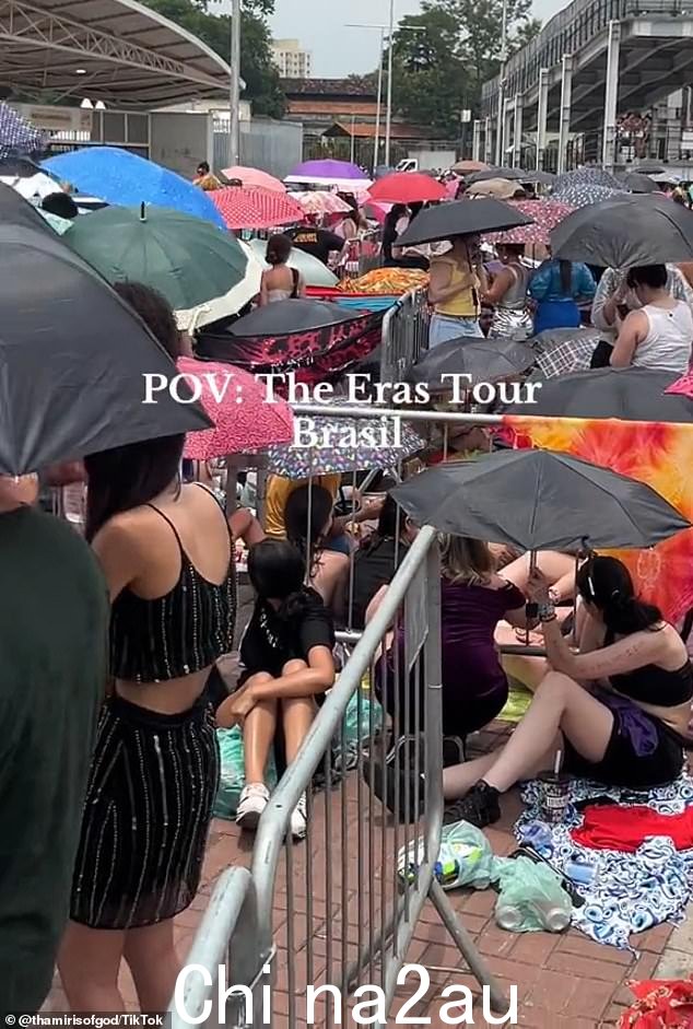 在巴西闷热的热浪中,衣着暴露的球迷挤在遮阳伞下,抢着拿冰块来降温