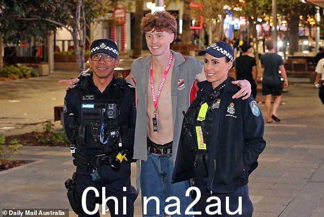 只有六名学生被捕,大部分是因为公共滋扰。相比之下,去年第一个周末后就有 18 名学生被捕。 (如图:一名青少年与两名警察合影;这并不表明他或本故事中照片中的任何人从事非法或反社会行为)