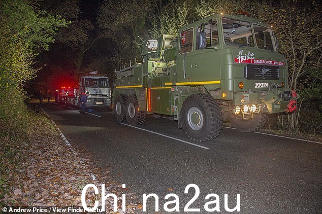 北威尔士贝德盖勒特附近汽车冲出道路坠毁现场的起重机和皮卡车