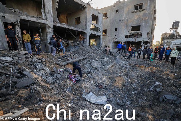 以色列周四袭击加沙地带南部汗尤尼斯后,救援人员在 al-Agha 家的废墟中寻找幸存者