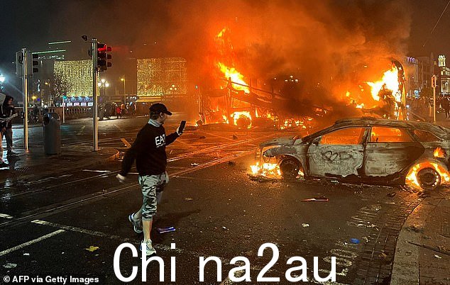 一名男子在昨晚的骚乱中记录了都柏林一辆被毁的汽车和一辆燃烧的公共汽车