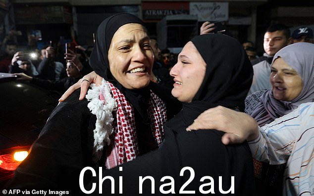 Rawda Abu Ajamieh(左)从以色列监狱获释后拥抱一位亲戚,这是以色列和哈马斯之间停战协议的一部分