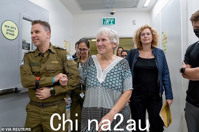 被释放的人质玛格丽特·莫斯泽斯,微笑着握住一名以色列士兵的手臂
