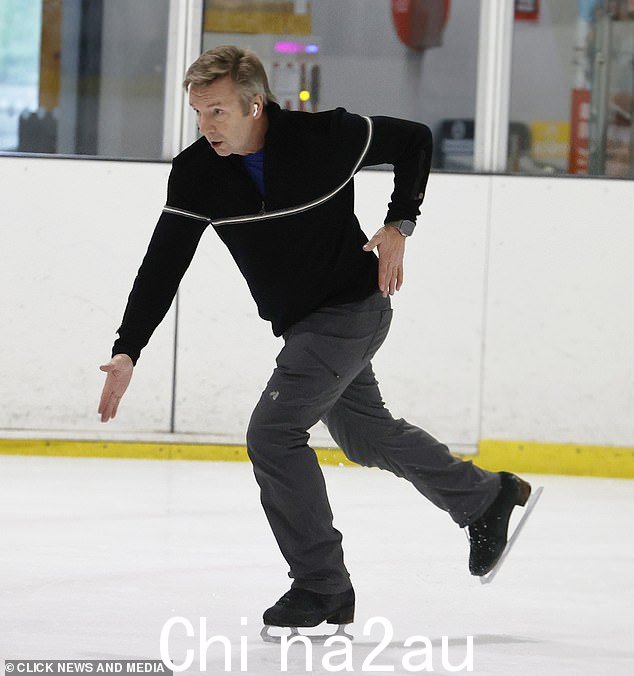 惊人:65 岁的 Christopher 穿着黑色四分之一拉链毛衣搭配灰色裤子和黑色溜冰鞋