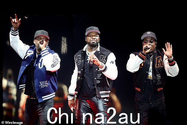50 Cent 在整体造型中添加了一件黑色 T 恤,以及一条沉重的金链和黑色帽子