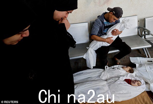 巴勒斯坦男子 Islam Harb 和他的亲属在他孩子的尸体旁做出反应