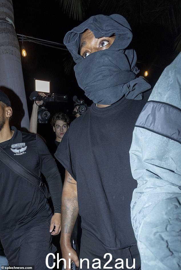 与此同时,Kanye 穿着黑色 T 恤和运动裤,塑造出休闲的身材,并用毛衣遮住了自己的脸