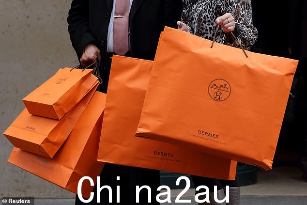 一对夫妇提着爱马仕购物袋离开巴黎爱马仕专卖店