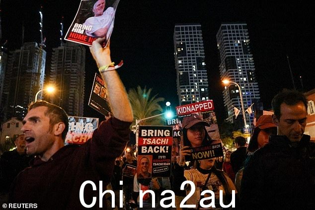 2023 年 12 月 15 日,以色列特拉维夫,以色列军方宣布误杀三名人质后,人们举着标语进行抗议