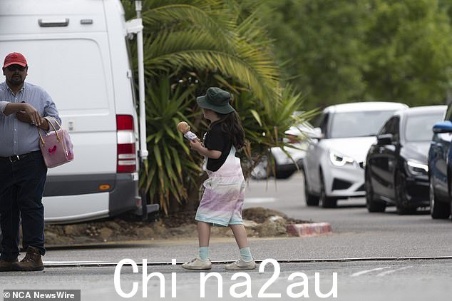 一个小女孩走向她的父亲,因为动物园在警方调查期间关闭,游客被告知离开动物园
