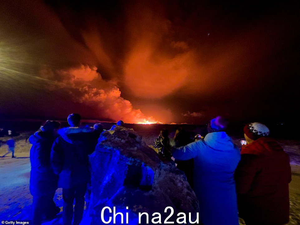周一晚上,人们观看格林达维克以北发电站附近的雷克雅内斯半岛火山喷发