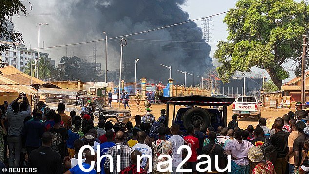 周二,人们从安全屏障后面观看爆炸现场