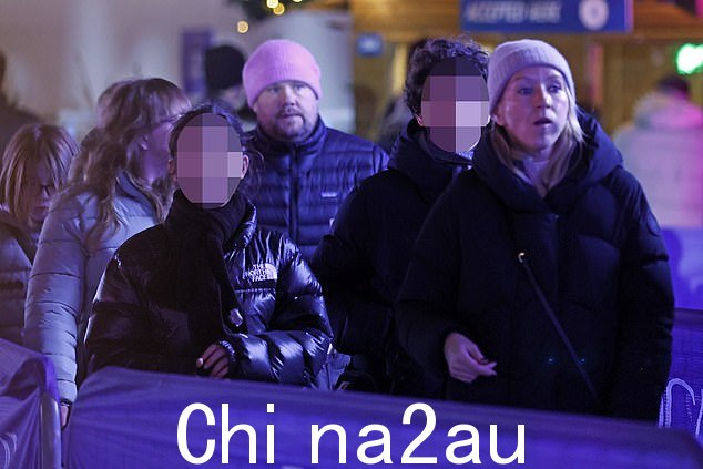 与她的丈夫 Julia 相匹配,47 岁,穿着舒适的超大黑色外套和灰色针织帽