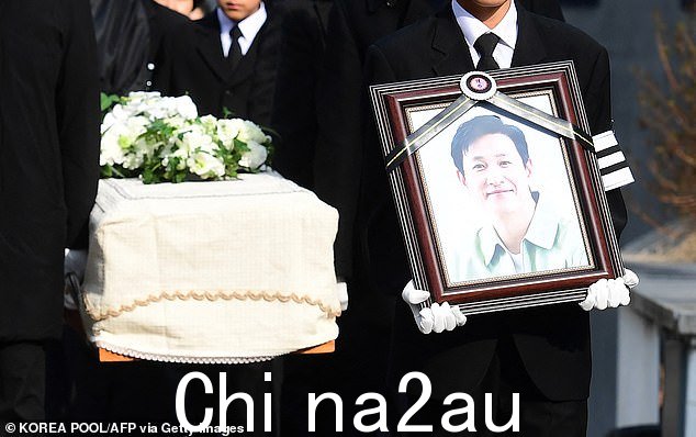 哀悼者抬着肖像和装有已故韩国演员李的棺材