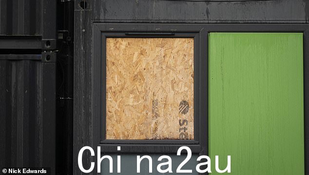 伦敦西部的集装箱公寓中,一扇破碎的窗户被用木板封住