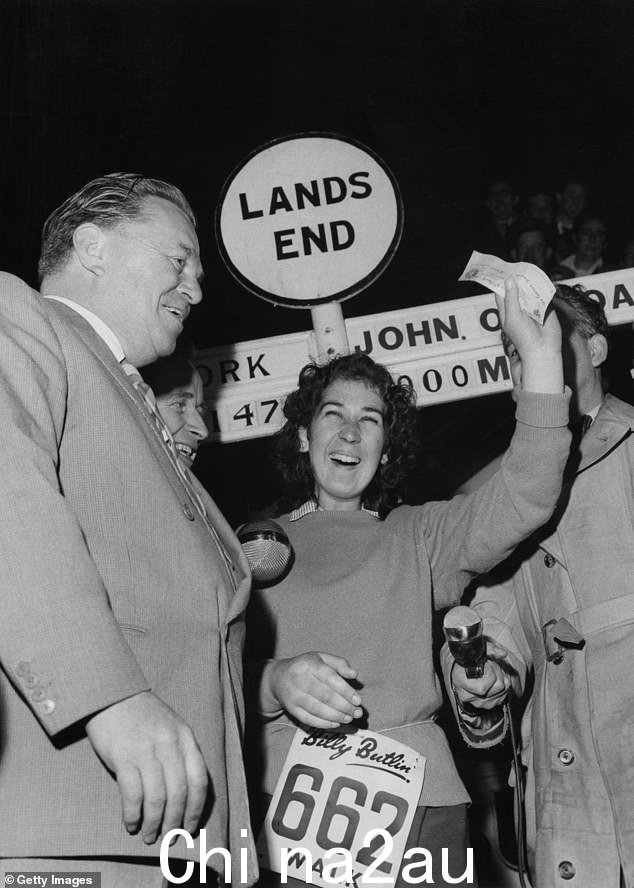 1960 年 3 月 16 日,温迪·刘易斯 (Wendy Lewis) 在完成由比利·布特林 (Billy Butlin) 组织的约翰·奥格罗茨 (John O' Groats) 到天涯海角 (Land's End) 步行比赛后,在获奖柱上举起奖品支票。