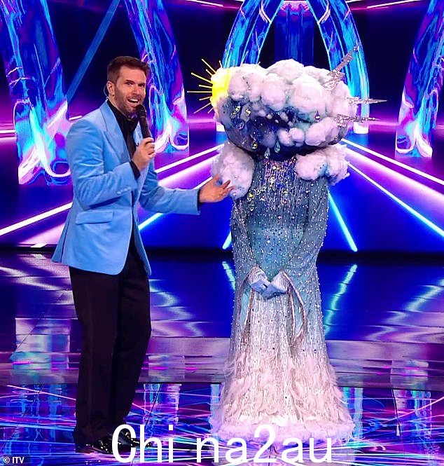 这位 83 岁的明星 - 有史以来最受瞩目的歌手之一 - 在剧集中透露了一些关于她身份的暗示(迪翁(右)穿着天气服装与主持人乔尔在一起)周六,多米特在《蒙面歌手》英国节目中)